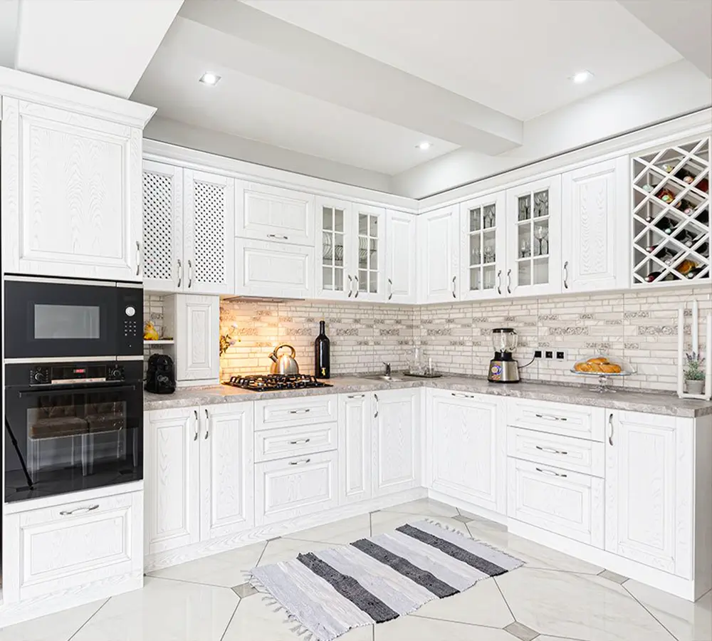 Elegant white kitchen with marble countertops, built-in wine rack, and bright natural lighting for a luxury look.