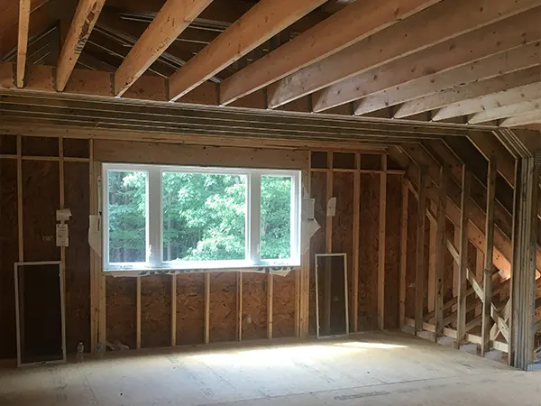 Framed interior of a home addition during the construction phase, showcasing modern craftsmanship and design potential.