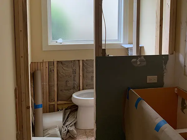 In-progress bathroom remodel with exposed framing and insulation.