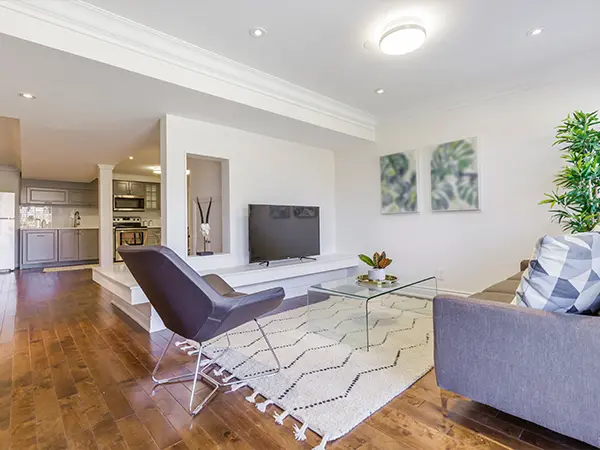 Modern living room with sleek furniture, glass coffee table, and hardwood flooring - perfect for a remodel.