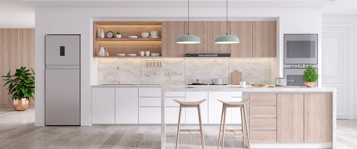 Contemporary minimalist kitchen with light wood cabinetry, marble backsplash, and pendant lighting over an island.