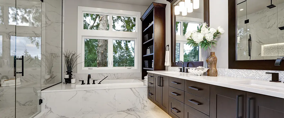 Luxurious modern bathroom with marble floors, large soaking tub, glass shower, and sleek dark wood cabinetry.