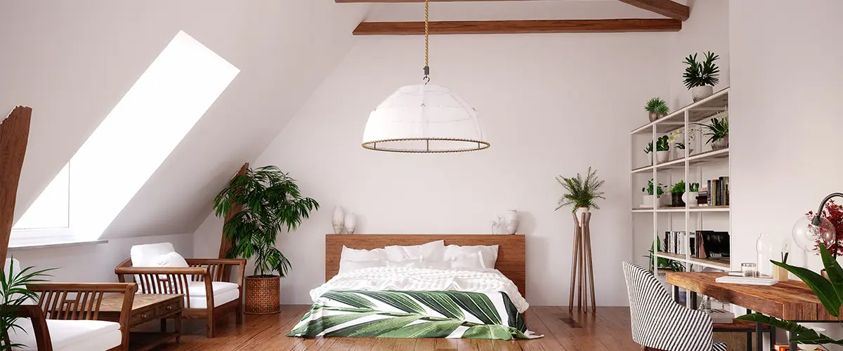 Modern attic bedroom with exposed wooden beams, lush greenery, and cozy furnishings, creating a serene and stylish retreat.