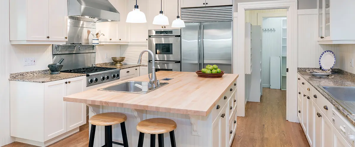 Modern farmhouse kitchen with a butcher block island, stainless steel appliances, and white cabinets for a bright, airy design.