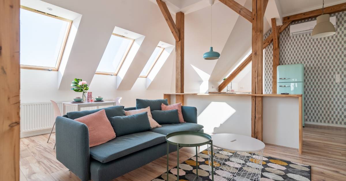 Stylish attic living space with skylights and wooden beams.