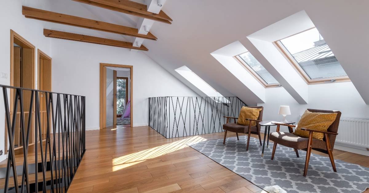 Open attic space with exposed beams, skylights, and seating area.