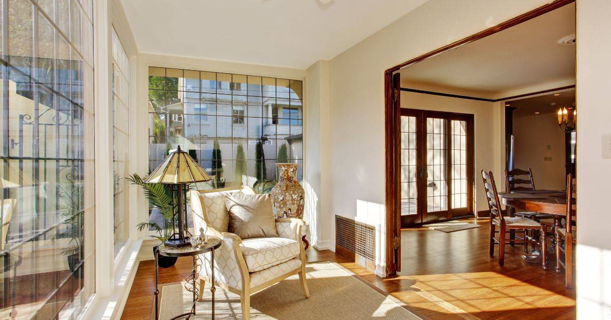 Elegant sunroom with armchair, side table, and large windows