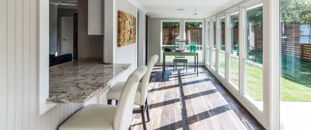 Bright sunroom with modern furniture and large glass doors