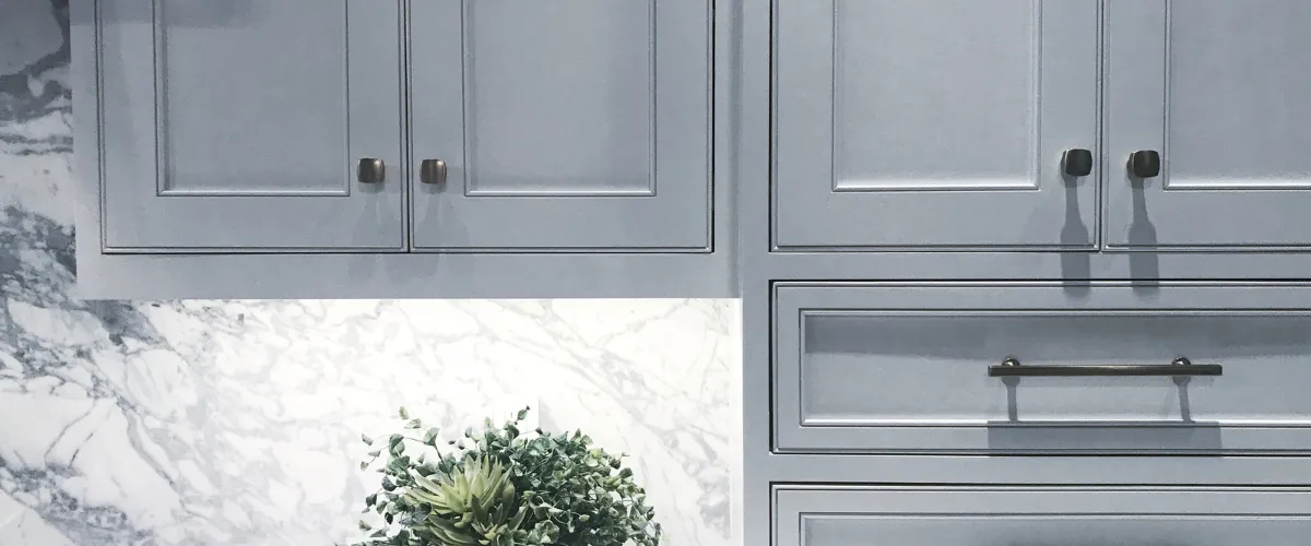 Close-up of gray kitchen cabinets with marble backsplash