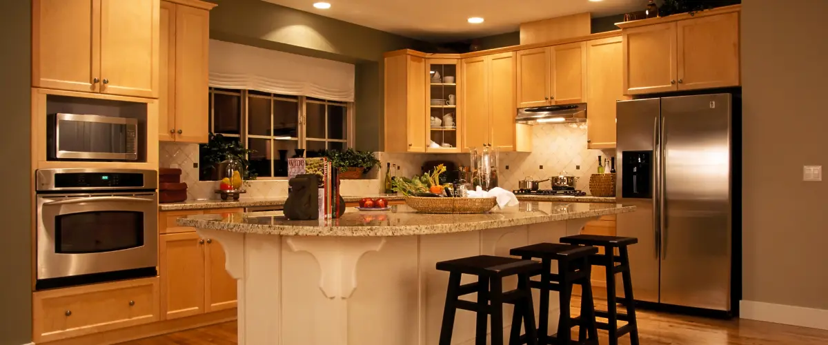 Warm-tone kitchen with granite countertops and recessed lighting